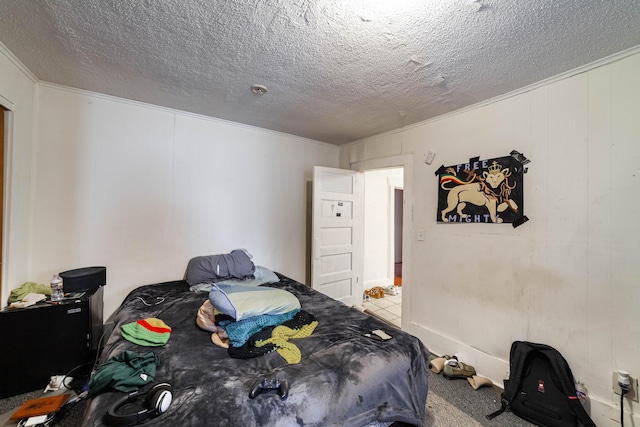 bedroom featuring a textured ceiling, light colored carpet, and ornamental molding