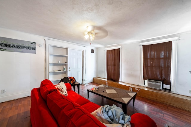 living room with a textured ceiling, cooling unit, wood-type flooring, and ceiling fan