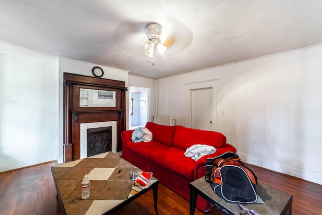 living room with dark wood-type flooring, radiator, and ceiling fan