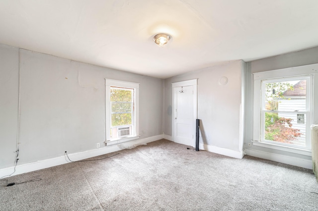 spare room with cooling unit, a healthy amount of sunlight, and carpet floors