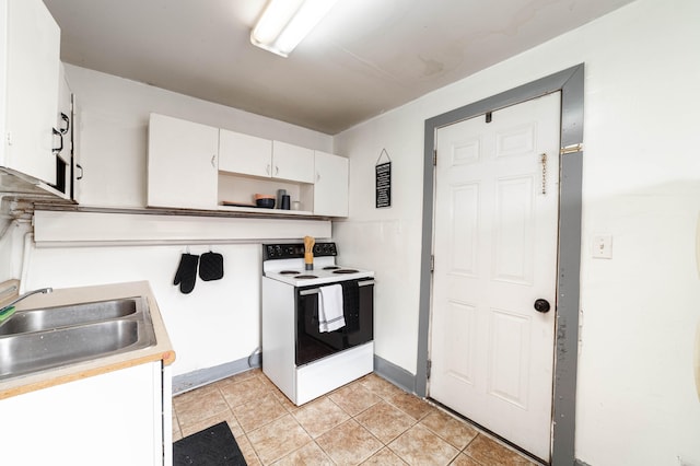 kitchen featuring light tile patterned floors, white cabinetry, sink, and white range with electric stovetop