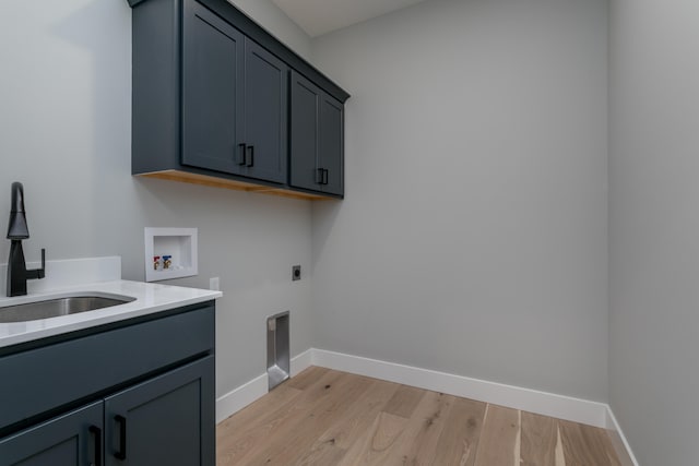 washroom with cabinets, sink, washer hookup, light wood-type flooring, and hookup for an electric dryer