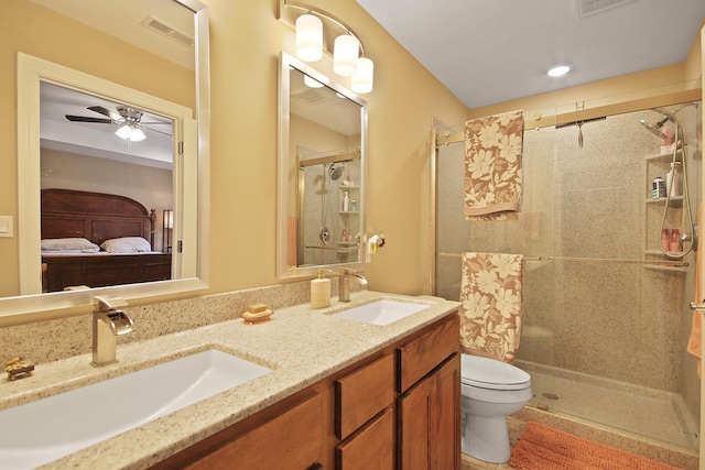 bathroom with vanity, ceiling fan, toilet, and a shower with door