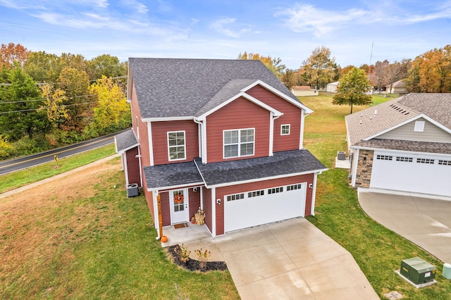 view of front of home with a garage, a front lawn, and central AC