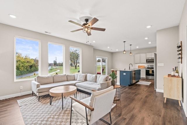 living room with ceiling fan, dark hardwood / wood-style floors, and sink