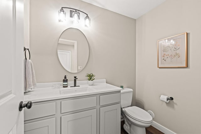 bathroom featuring toilet, vanity, and wood-type flooring