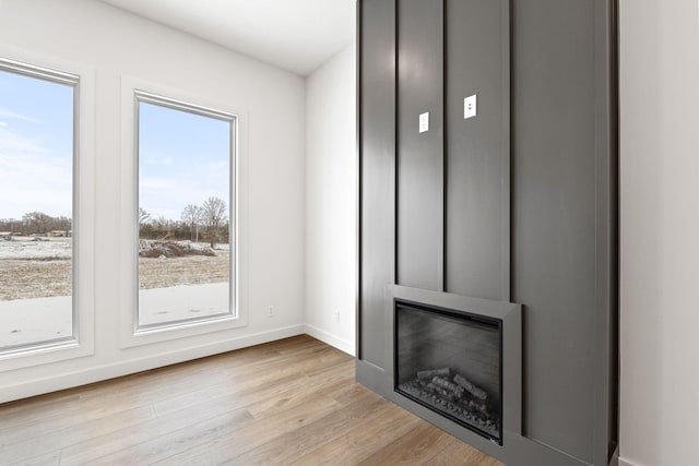 unfurnished living room featuring light wood-type flooring and a large fireplace