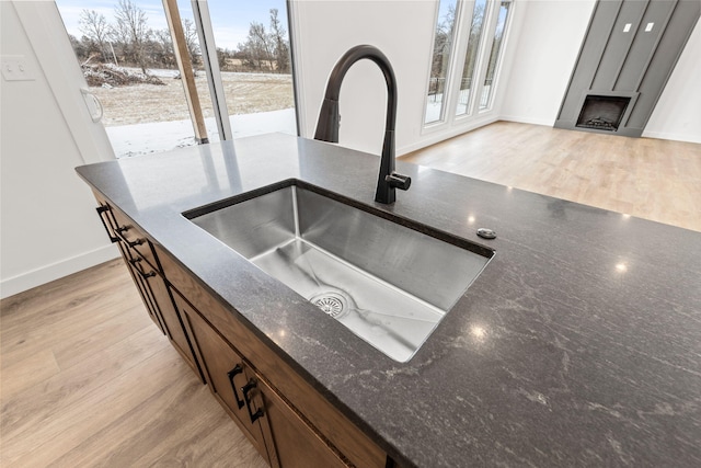 interior details with light wood-type flooring and sink