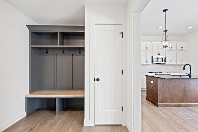 mudroom featuring sink, a notable chandelier, and light hardwood / wood-style flooring