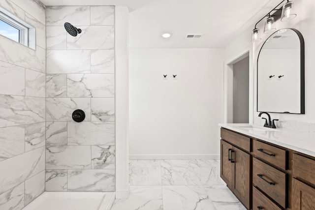 bathroom with tiled shower and vanity