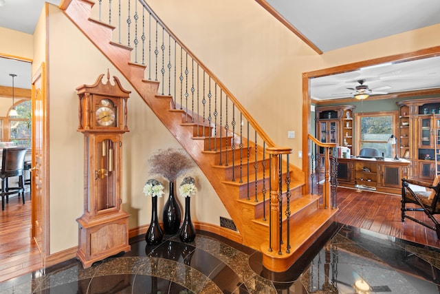 stairway with crown molding and hardwood / wood-style flooring