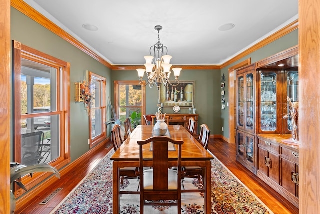 dining room featuring crown molding, hardwood / wood-style flooring, and a wealth of natural light