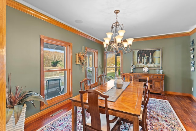 dining room with ornamental molding, a chandelier, and dark wood-type flooring