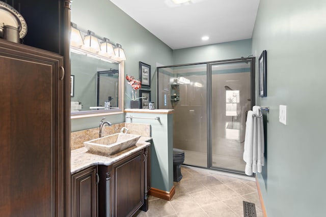 bathroom with vanity, tile patterned flooring, toilet, and an enclosed shower