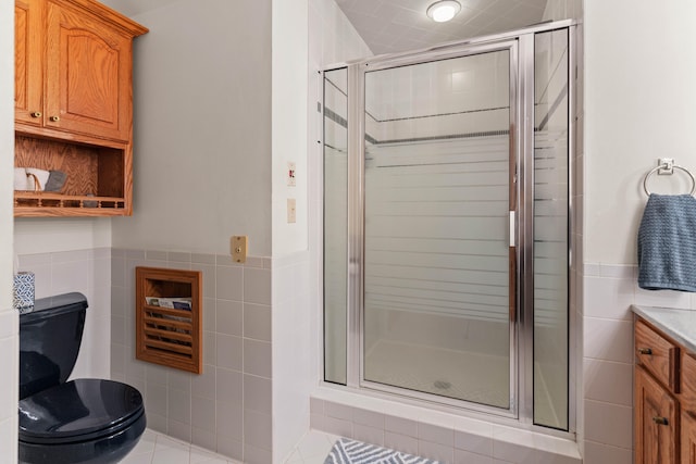 bathroom with vanity, a shower with shower door, tile walls, and tile patterned flooring