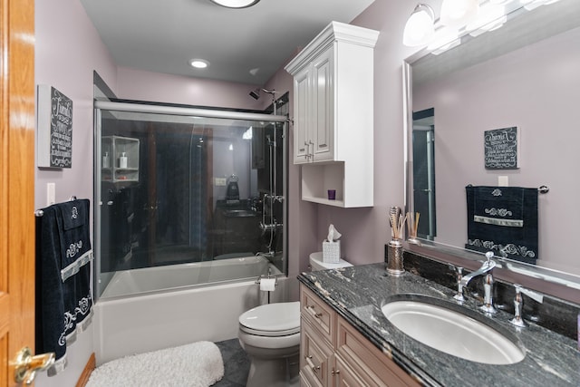 full bathroom with vanity, toilet, and combined bath / shower with glass door