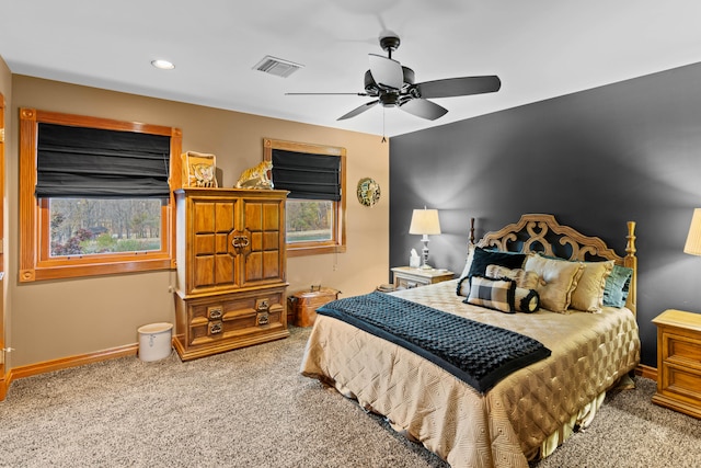 carpeted bedroom with multiple windows and ceiling fan