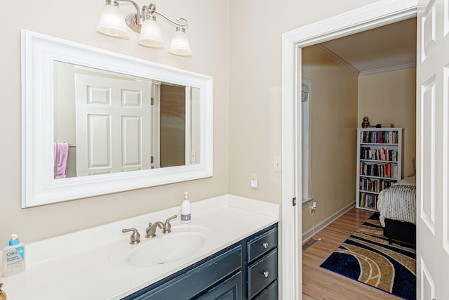 bathroom featuring vanity, hardwood / wood-style flooring, and crown molding