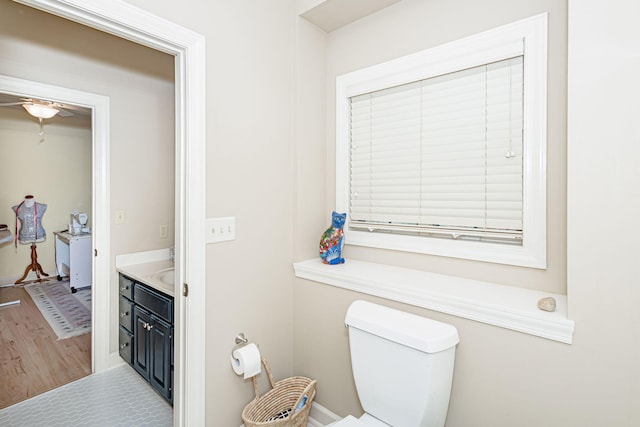 bathroom with ceiling fan, hardwood / wood-style floors, vanity, and toilet