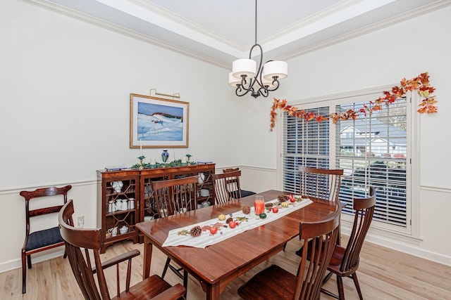 dining area with crown molding, light hardwood / wood-style flooring, and a notable chandelier