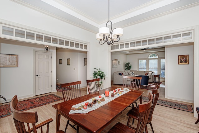 dining space with light hardwood / wood-style floors, a notable chandelier, and ornamental molding