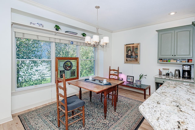 dining area featuring a notable chandelier, crown molding, and light hardwood / wood-style flooring