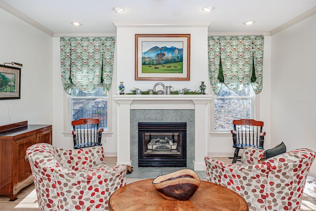 living area with a fireplace, crown molding, and light hardwood / wood-style flooring