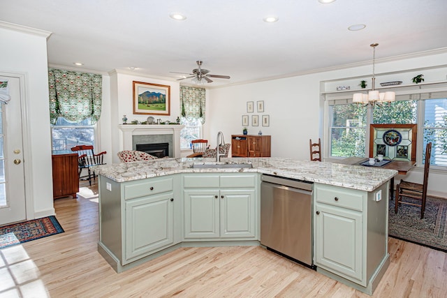 kitchen featuring decorative light fixtures, a center island with sink, stainless steel dishwasher, and sink