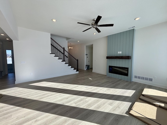 unfurnished living room with ceiling fan, a fireplace, and hardwood / wood-style flooring