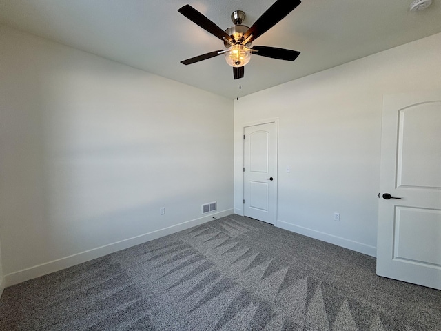 unfurnished room with ceiling fan and dark carpet