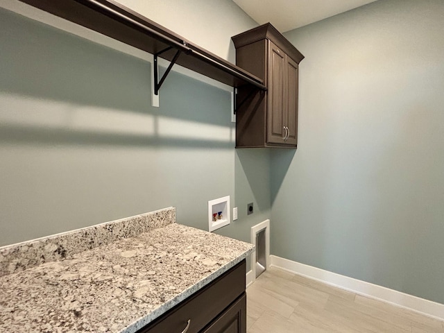 washroom with electric dryer hookup, hookup for a washing machine, and cabinets