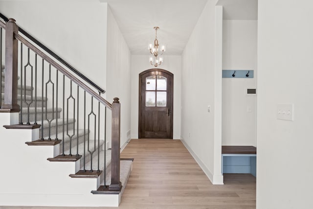 6504 Walsby Dr, Columbia, MO 65201 - foyer featuring arched walkways, light wood-type flooring, baseboards, a chandelier, and stairs