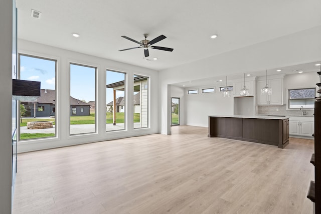 6504 Walsby Dr, Columbia, MO 65201 - unfurnished living room featuring light wood finished floors, visible vents, a sink, and recessed lighting