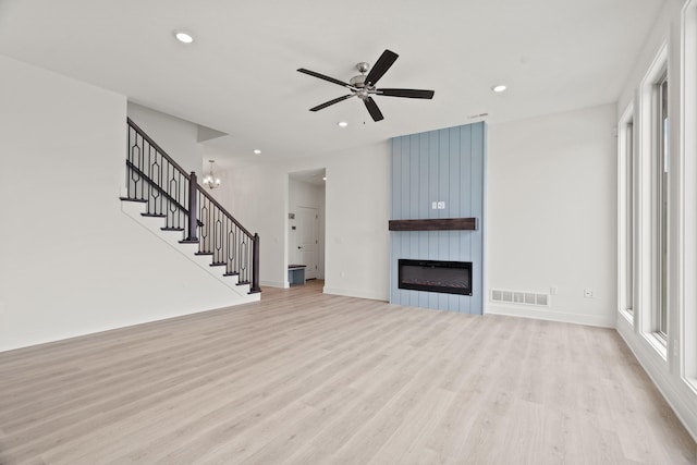 6504 Walsby Dr, Columbia, MO 65201 - unfurnished living room featuring light wood-style floors, visible vents, stairs, and ceiling fan with notable chandelier