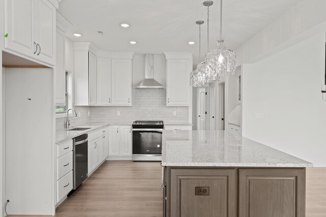 6504 Walsby Dr, Columbia, MO 65201 - kitchen featuring wall chimney range hood, a sink, white cabinetry, appliances with stainless steel finishes, and a kitchen island