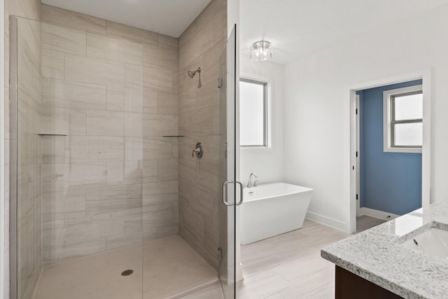 6504 Walsby Dr, Columbia, MO 65201 - bathroom with a soaking tub, baseboards, vanity, and a stall shower