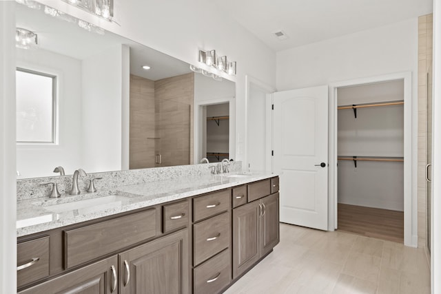 6504 Walsby Dr, Columbia, MO 65201 - bathroom featuring a spacious closet, visible vents, a sink, and a stall shower