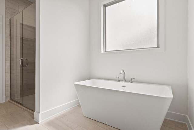 6504 Walsby Dr, Columbia, MO 65201 - bathroom featuring baseboards, a freestanding tub, and a stall shower