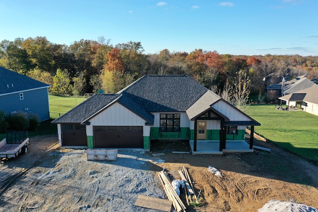 modern farmhouse featuring a garage, covered porch, and a front yard