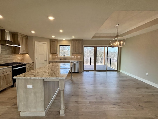 kitchen with a sink, a center island, dishwasher, wall chimney exhaust hood, and gas range