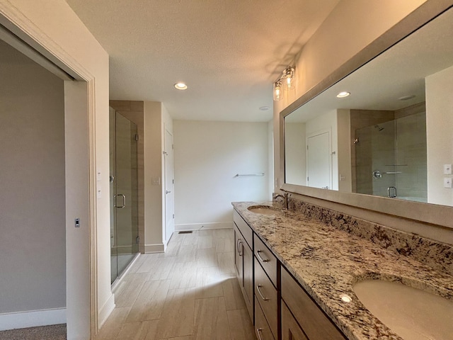 full bath with double vanity, a sink, and a shower stall