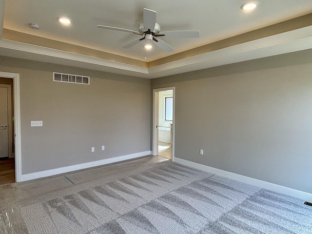 carpeted empty room featuring baseboards, visible vents, a raised ceiling, ceiling fan, and recessed lighting