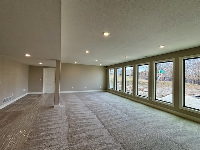 unfurnished living room featuring light carpet, plenty of natural light, and visible vents