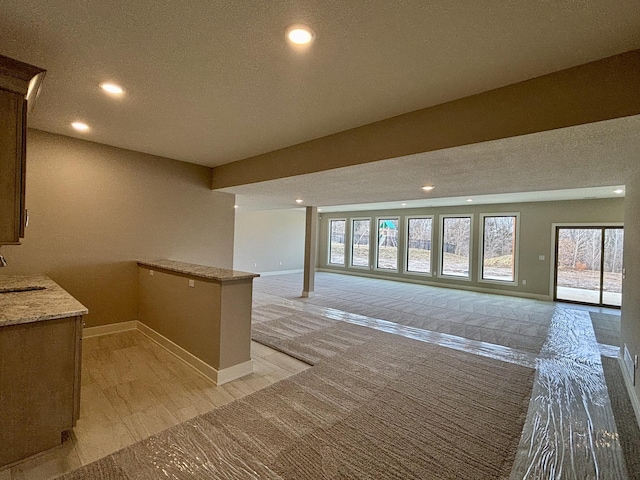 bar featuring recessed lighting, a sink, and baseboards