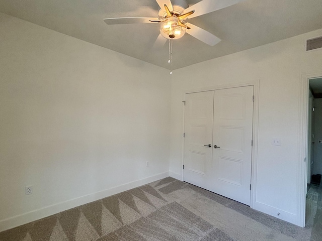 unfurnished bedroom featuring light carpet, baseboards, visible vents, ceiling fan, and a closet