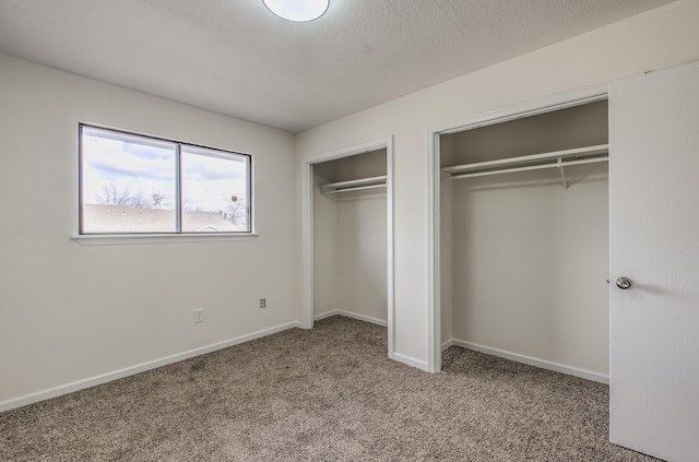 unfurnished bedroom featuring multiple closets and carpet