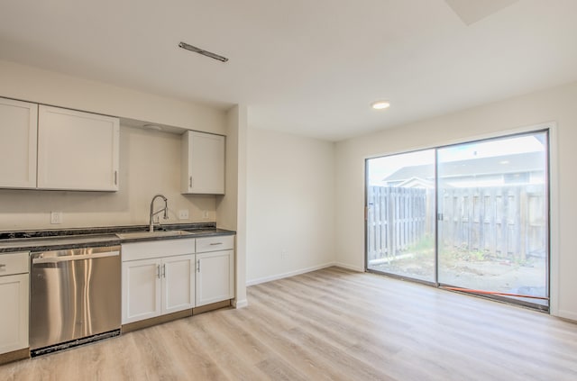 kitchen featuring white cabinetry, stainless steel dishwasher, sink, and light hardwood / wood-style floors