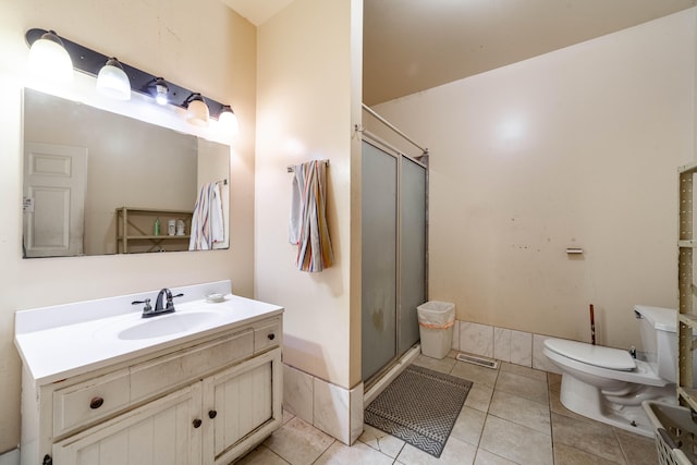 bathroom with toilet, vanity, tile patterned flooring, and a shower with door