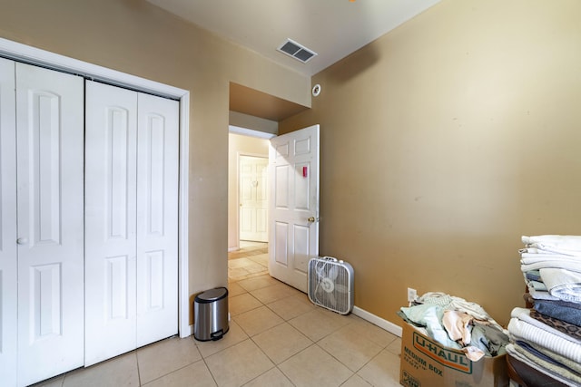 unfurnished bedroom featuring light tile patterned floors and a closet