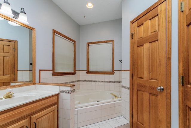 bathroom featuring vanity and a relaxing tiled tub